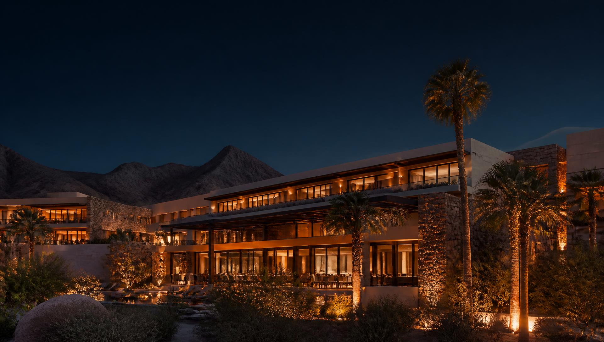 Upper-upscale desert resort hotel exterior lit at dusk